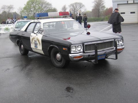 1991 Ford LTD Crown Victoria - black-and-white Dodge California Highway Patrol sedan with a push bar and roof lightbar parked near uniformed onlookers.