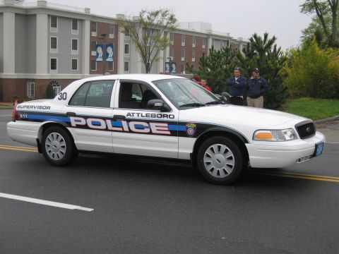 1991 Ford LTD Crown Victoria - Rear three-quarter view of a white Attleboro Police supervisor Ford Crown Victoria on a parade street.