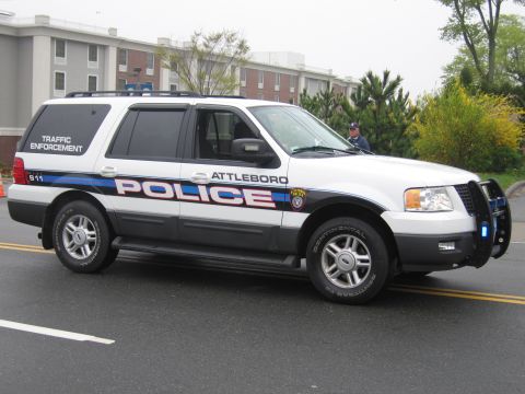 1991 Ford LTD Crown Victoria - Side view of a white Attleboro Police Ford Expedition Traffic Enforcement SUV with push bar on a wet street.
