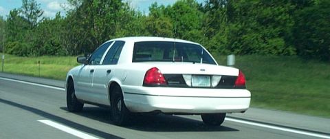 2001 Ford Crown Victoria - White 2001 Ford Crown Victoria seen from behind on a highway.