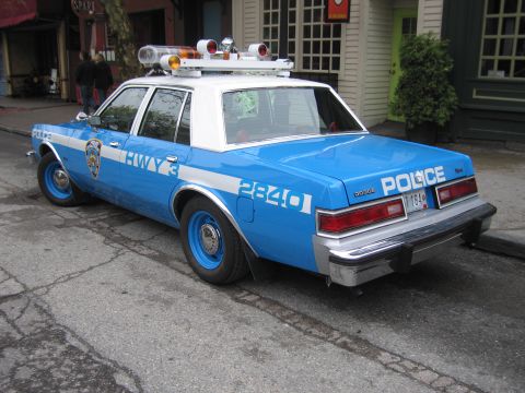 1991 Ford LTD Crown Victoria - Rear three-quarter view of a blue-and-white NYPD Highway police sedan marked 2840 with rooftop lights parked curbside.