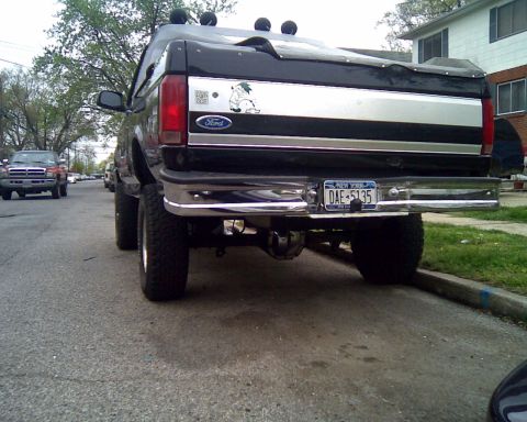 1995 Ford Bronco - Rear view of a black 1995 Ford Bronco, a custom decal and lifted suspension.