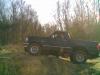 1995 Ford Bronco - A black pickup truck is seen from the side in a natural setting.