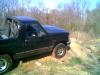 1995 Ford Bronco - A black pickup truck is seen from a 3q-front angle while driving off-road.