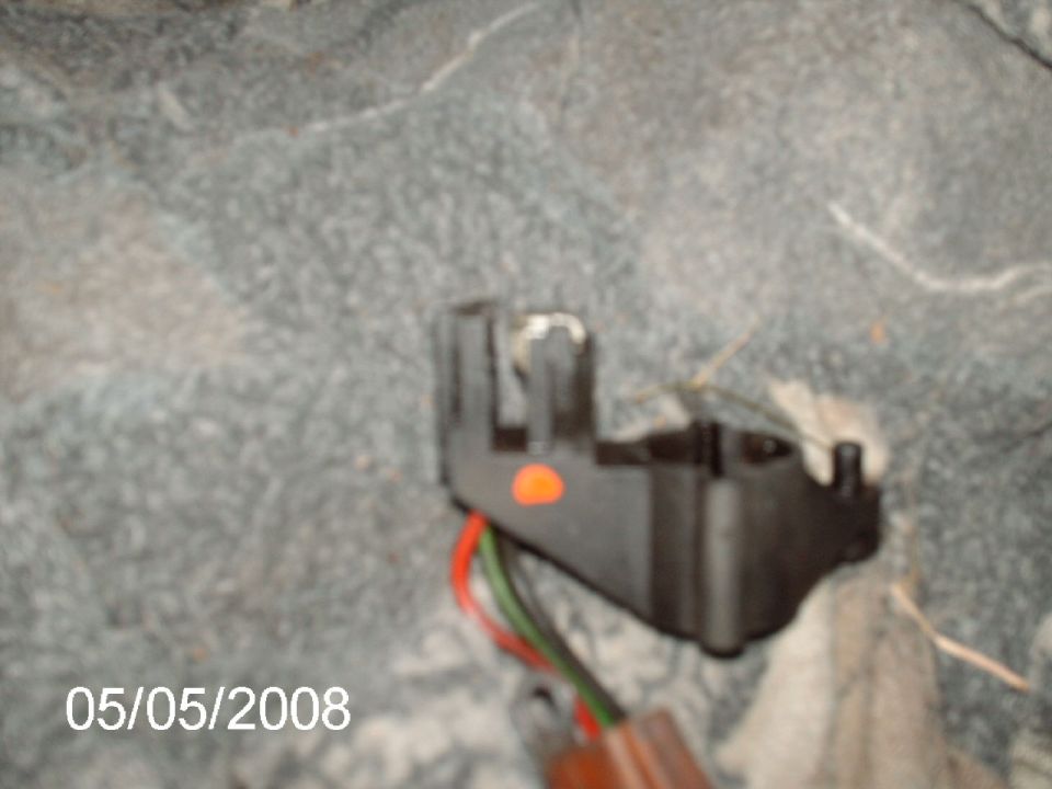 Black electrical connector with red and green wires, orange dot, and Supermotors.net watermark