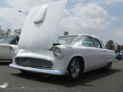 1968 Ford Mustang - A classic white Ford Thunderbird is displayed with its hood up, parked outdoors on a sunny day.