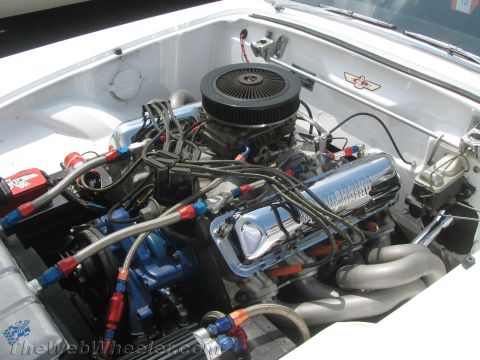 1968 Ford Mustang - Close-up view of a modified V8 engine with custom fuel lines and polished components.