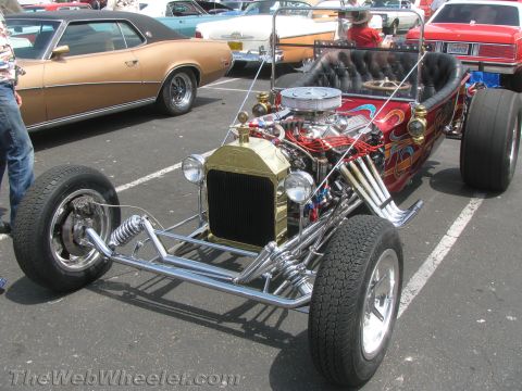 1968 Ford Mustang - A custom hot rod with a prominent V8 engine and flame decals sits in a parking lot.