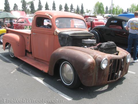 1968 Ford Mustang - A weathered pickup truck sits in a parking lot, its engine exposed and body showing signs of age.
