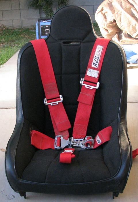 2008 Ford Bronco - A black racing seat with a red five-point harness is shown, with a generator in the background.