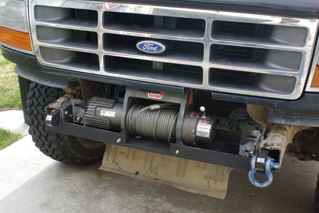 Warn winch on fabricated mount under Ford grille, bumper off, blue D-ring shackle