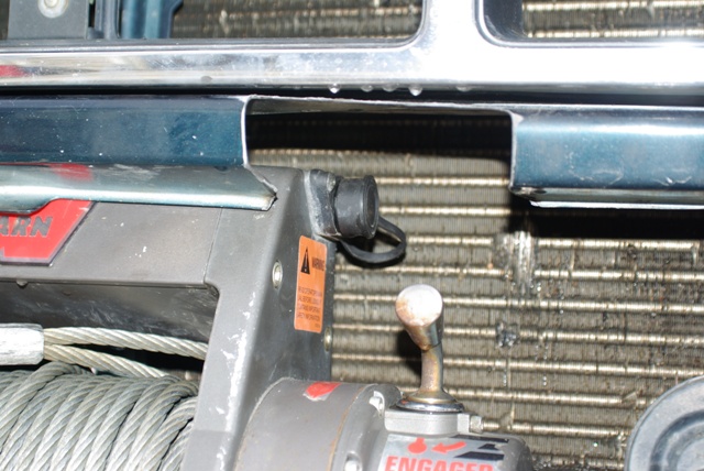 Warn winch clutch lever in ENGAGED position with warning decal, radiator behind