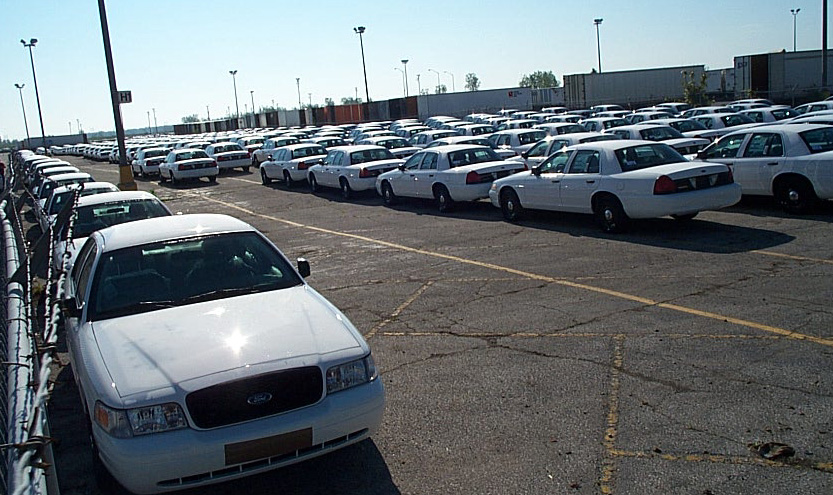 2001 Ford Crown Victoria parked in a lot with many other white sedans