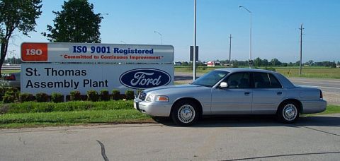 2001 Ford Crown Victoria - A silver Ford Crown Victoria is parked next to a sign for the St. Thomas Assembly Plant.