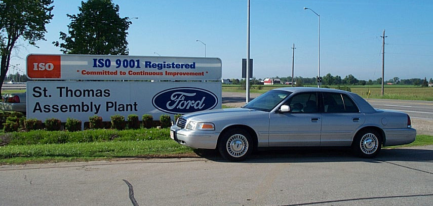 Silver 2001 Ford Crown Victoria parked by a sign for St. Thomas Assembly Plant