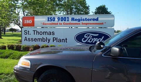 2001 Ford Crown Victoria - A dark sedan is parked in front of the St. Thomas Assembly Plant sign.