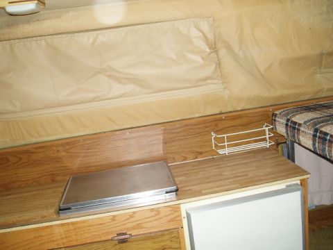 1980 Ford Bronco - Interior view of a camper van, showing a built-in stove, countertop, and seating area.