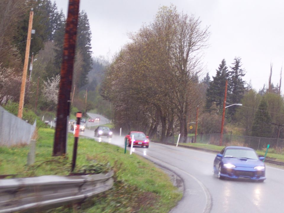 Blue coupe driving on a wet road