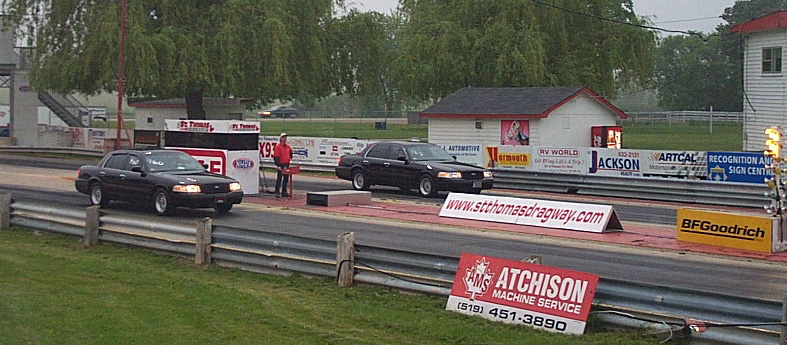 Two black 2001 Ford Crown Victorias at drag strip start line