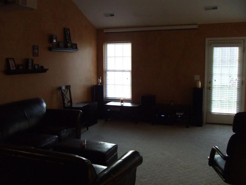 Living room with sectional sofa, coffee table, and projection screen.