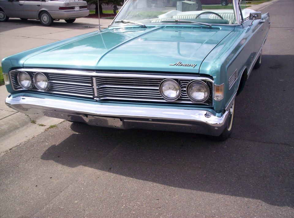 Teal 1960s Mercury convertible, front three-quarter view with chrome grille and bumper