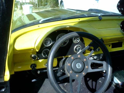 1972 Ford Ranchero - The interior of a classic yellow Ford Ranchero shows a custom steering wheel and dashboard with multiple gauges. The view is from the drive…