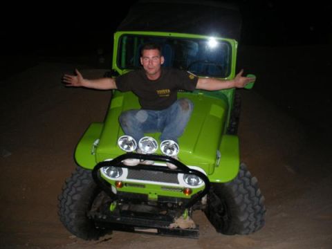1993 Ford Bronco - An off-road vehicle is seen from the front at night, its headlights illuminating the scene.