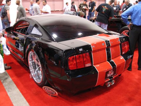 1998 Ford Crown Victoria - Rear view of a black car adorned with bold red racing stripes.