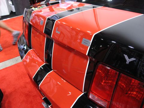 1998 Ford Crown Victoria - The rear of a car displays bold red, black, and white racing stripes with prominent badging.
