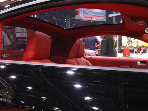 1998 Ford Crown Victoria - Interior view of a car with red seats and a sunroof, showing people in the background.