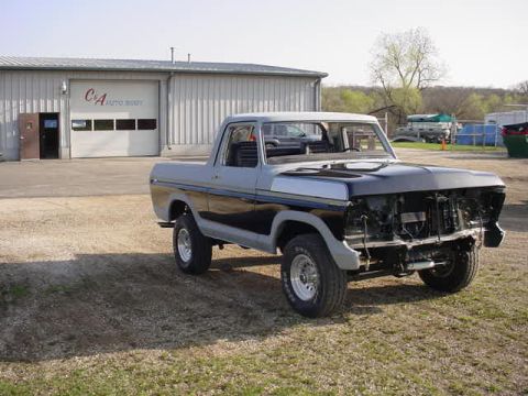 1979 Ford Bronco - This 1979 Ford Bronco is missing its grille and appears to be undergoing repairs at an auto body shop.