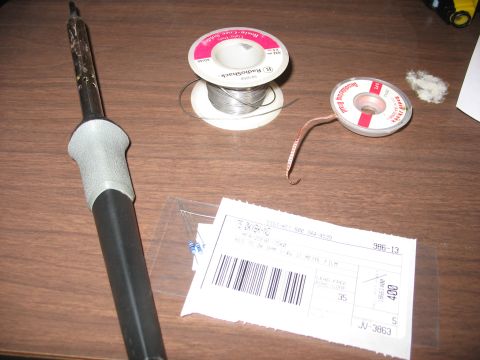 1995 Ford C-350 (Centurion Conversions) - A soldering iron, solder, resistors, and a shipping label are arranged on a wooden desk.