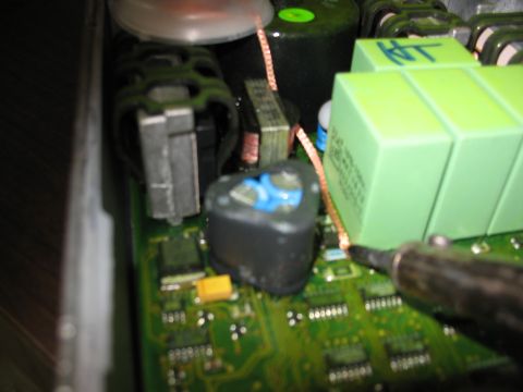 1995 Ford C-350 (Centurion Conversions) - A close-up view shows a soldering iron connecting a copper wire to a complex circuit board.
