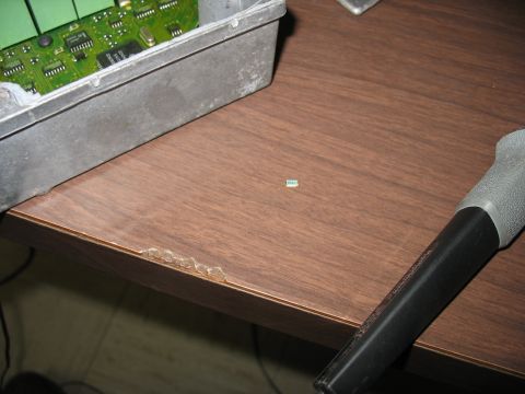 1995 Ford C-350 (Centurion Conversions) - An electronic control unit with its internal circuit board exposed sits on a wooden surface next to a small label.