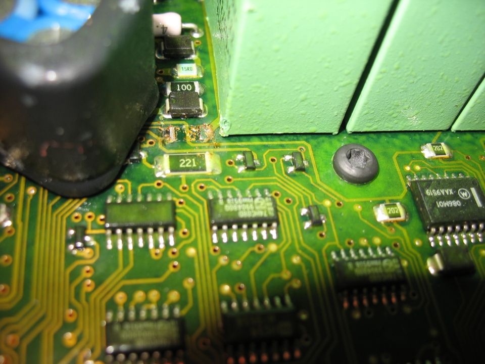Close-up of a green circuit board with various electronic components, including chips and resistors