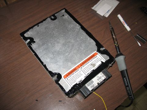 1995 Ford C-350 (Centurion Conversions) - A Ford electronic control module is shown with warning labels and a soldering iron, suggesting repair or modification.