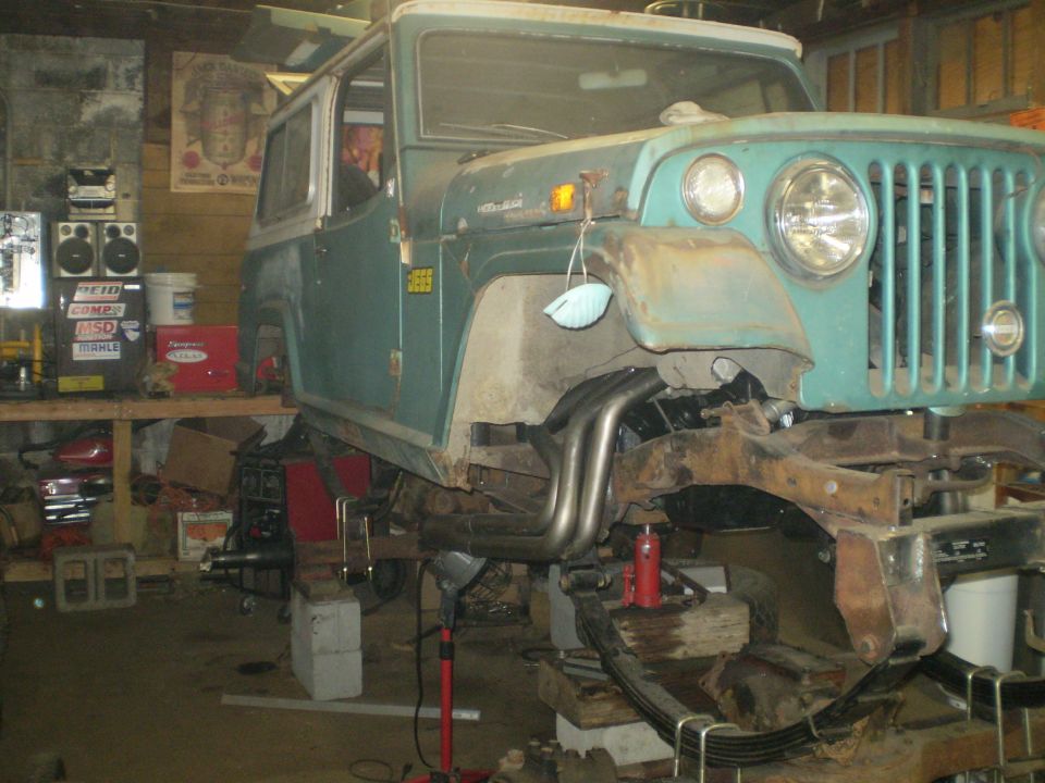 Teal Jeep CJ-5 front view, undergoing repairs