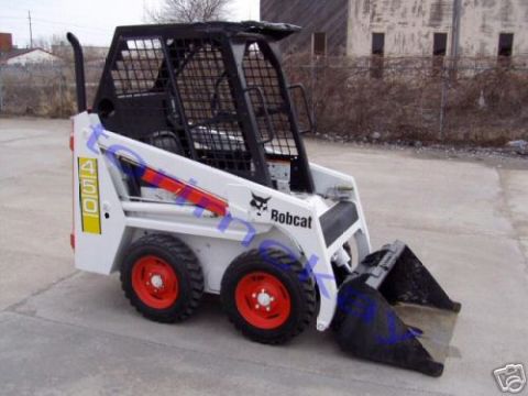 1946 Ford F1 - A white Bobcat skid steer loader is parked on a concrete surface outdoors.