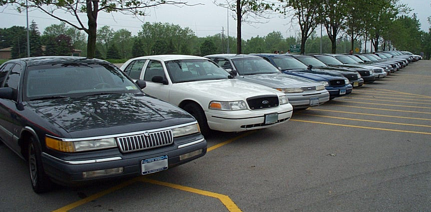 Dark sedan, 2001 Ford Crown Victoria, parked in a lot, front 3/4 view