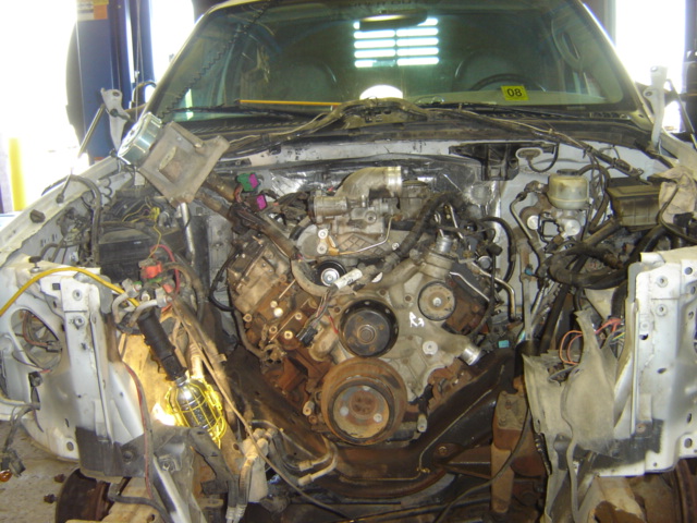 Truck engine bay with engine exposed, wiring and hoses visible
