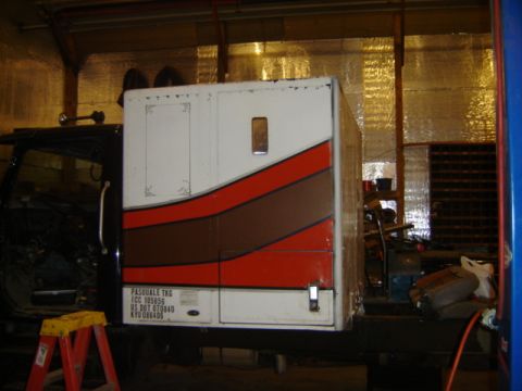 1992 Ford Bronco - A truck cab is attached to a white sleeper with red and brown stripes, seen from the side.