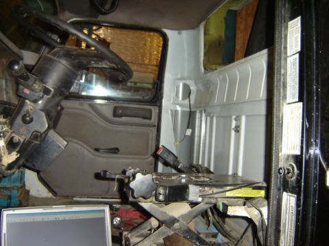 1992 Ford Bronco - The interior of a truck cab is shown, with a laptop in the foreground and a view into the cargo area.