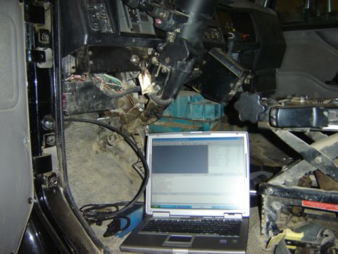 1992 Ford Bronco - Diagnostic computer connected to exposed wiring under the dashboard of a vehicle.