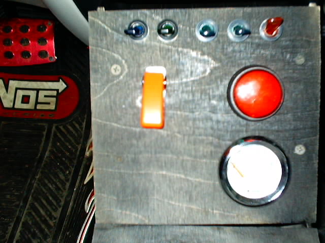 Custom dashboard with NOS logo floor mat, toggle switches, a red button, and a gauge