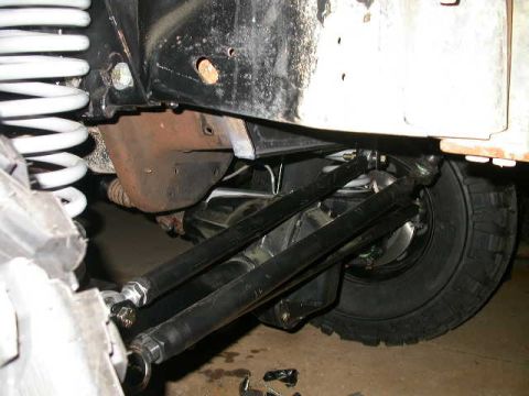 1990 Ford Bronco - Underbody view of a fabricated three-link/radius-arm suspension with black tubular links and heim-jointed ends running back to frame-mounte…