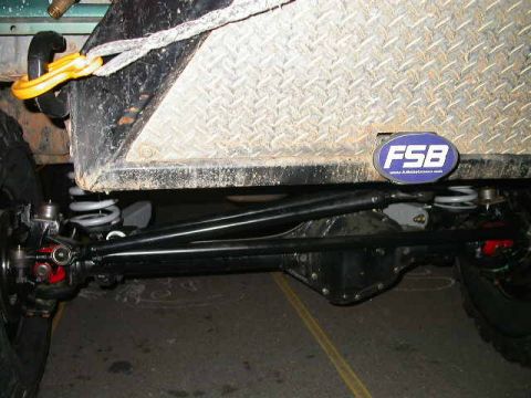 1990 Ford Bronco - Close-up view of vehicle suspension components and a diamond plate panel with an FSB badge.