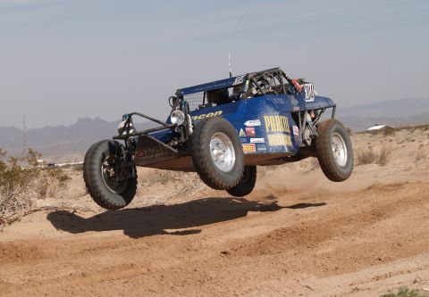 2008 Ford Bronco - This off-road buggy is captured mid-air during a race, kicking up dust from the track below.