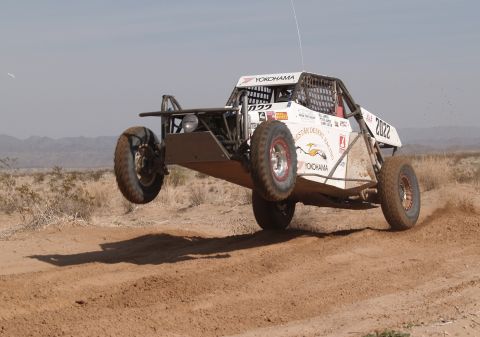 2008 Ford Bronco - An off-road buggy jumps over a dirt track in a desert environment.