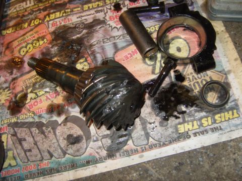 1989 Ford Bronco - Damaged differential components are laid out on a newspaper, indicating a recent failure.