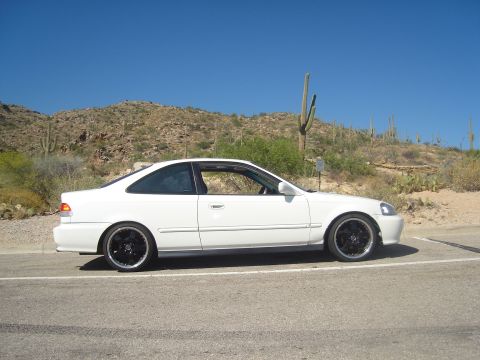 1997 Ford Probe - A white coupe sits on the side of a road with a desert landscape behind it.
